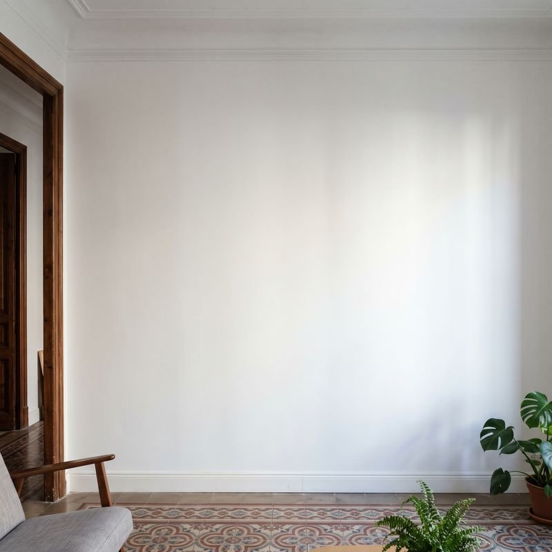 Pared lisa pintada de blanco después de quitar el gotelé, en un piso con suelo hidráulico